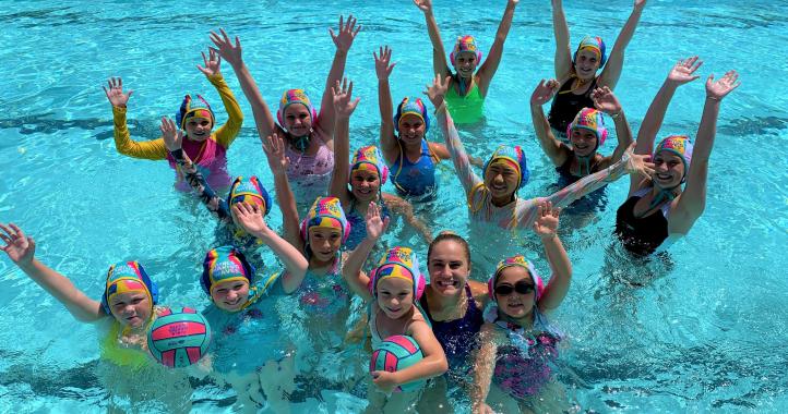 Group of girls in pool playing water polo